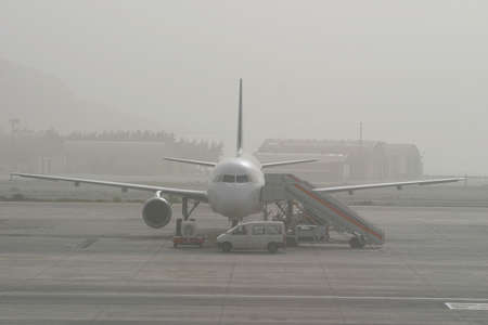  A passenger aircraft fogbound on a runway waiting to take offの写真素材