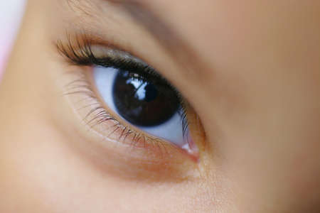 A close up of a child's brown eye shot with  a very shallow depth of fieldの写真素材