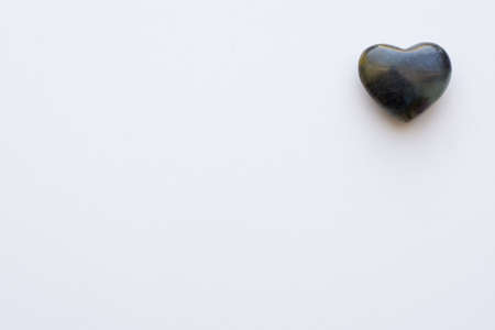 A black Agate stone heart shot on a white background with room for textの写真素材