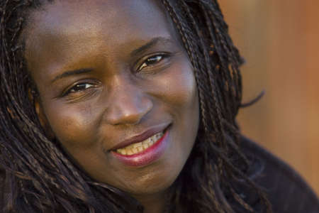 A beautiful young black woman with braided hair smiling for the cameraの写真素材