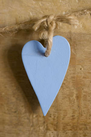 A blue wooden heart hanging on a stringの写真素材