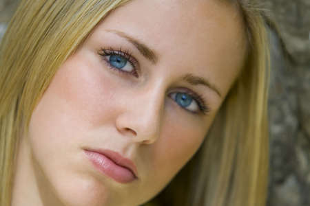 A beautiful young blonde woman stares enigmatically into the cameraの写真素材