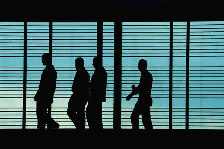 Silhouettes of workers/executives in front of a hi tech backgroundの写真素材