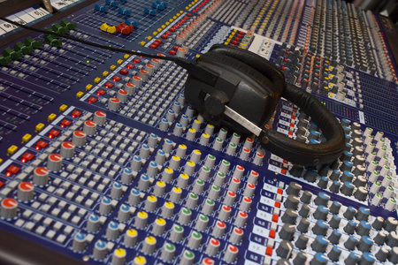 Close up of an audio visual mixing desk complete with headphones