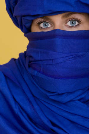 Beautiful blue eyes look out from behind an indigo veilの写真素材