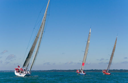 A group of 3 yachts sailing on a summer's day.