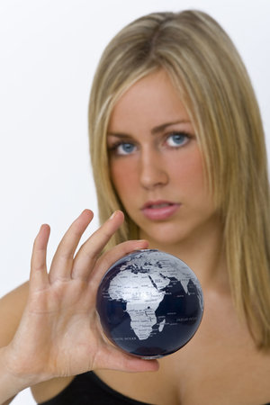 A beautiful young woman holding a globe in her hand, the focus is on the globe and Africa in...