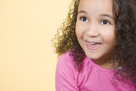 Studio shot of a beautiful young mixed race girl smiling and looking up