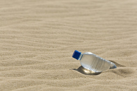 A bottle of mineral water in the sand of a bone dry desert