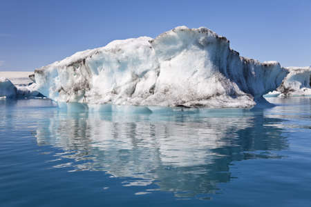 A glacial iceberg and its symmetrical reflection floating on the Iceberg Lagoon, Jokulsarlon, Icelandの写真素材