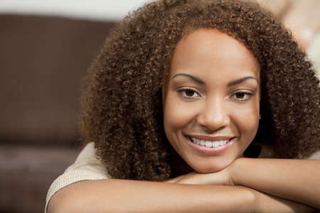 A beautiful miced race African American girl laying down with perfect teeth and smileの写真素材