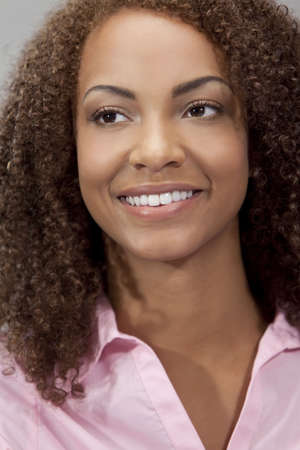 A beautiful mixed race African American girl laying down with perfect teeth and smileの写真素材