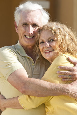 A senior retired man and woman couple hugging and happy together.