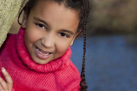 Portrait photograph of a beautiful young smiling happy mixed race interracial African American girl,...