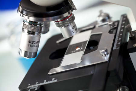 Close up macro photograph of microscope with slide in a scientific research laboratory.の写真素材
