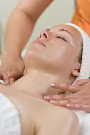 A young woman relaxing at a health spa while having a facial treatment or relaxing massageの写真素材