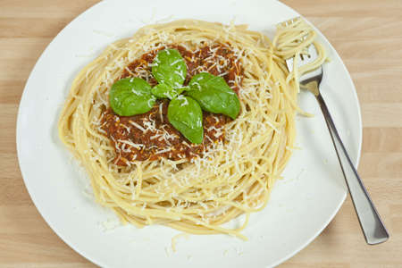 Spaghetti Bolognese with basil garnish and grated Parmesan cheeseの写真素材