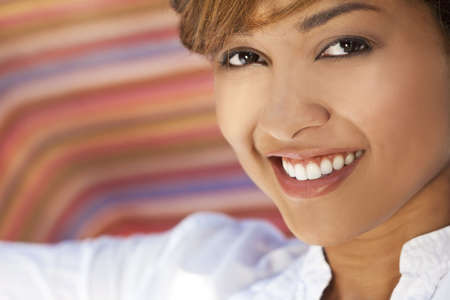 A beautiful mixed race young woman with perfect teeth and smileの写真素材