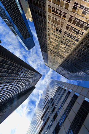 HDR Photograph of the exterior of a modern office city building skyscrapers reaching into a blue sky with  cloudsの写真素材