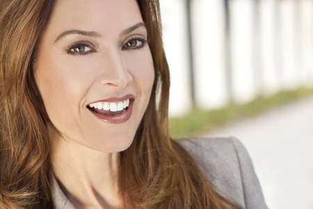Outdoor portrait of a beautiful smiling young brunette woman or businesswoman in her thirtiesの写真素材