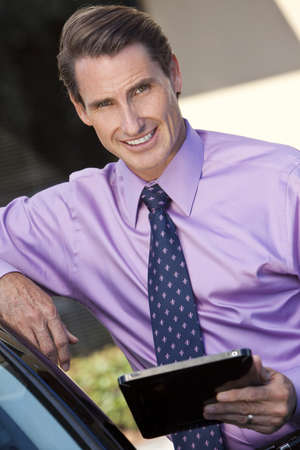 A smart successful businessman outside using a tablet computer の写真素材