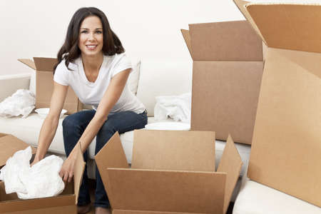A beautiful single young woman unpacking boxes and moving into a new home.の写真素材