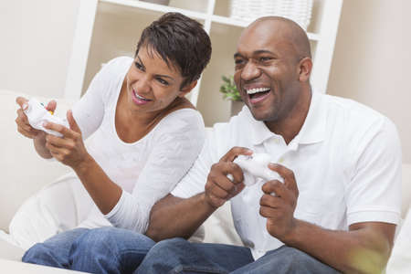 African American couple, man and woman, having fun playing video console games togetherの写真素材