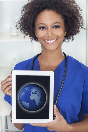 An African American female woman medical doctor with a tablet computer in hospital with a world map...