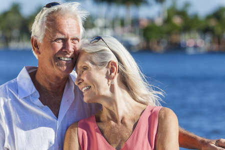 Happy romantic senior man and woman romantic couple together embracing by tropical sea or riverの写真素材