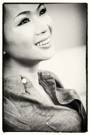 Black and white photograph of a beautiful young Chinese Asian woman with a wonderful toothy smile の写真素材