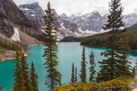 Moraine Lake, a glacially-fed lake in Banff National Park, Alberta, Canada, situated in the Valley of the Ten Peaks  Surrounded by the snow covered peaks of the Rocky Mountains の写真素材