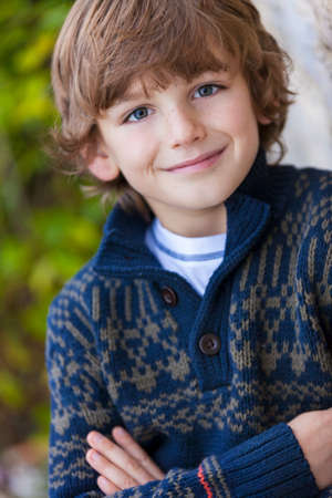 Young happy smiling boy outside arms foldedの写真素材