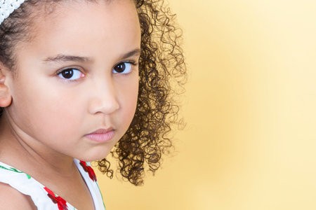 A beautiful mixed race African American little girl female child looking sad and sulking