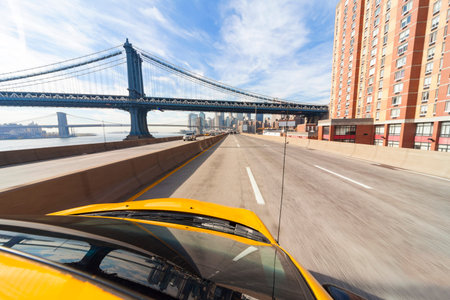 New York City yellow taxi cab driving under Manhattan Bridge