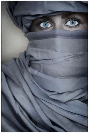 Beutiful young woman female with blue eyes wearing a blue veilの写真素材