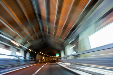 Motion blur driving a car at speed through a road tunnel