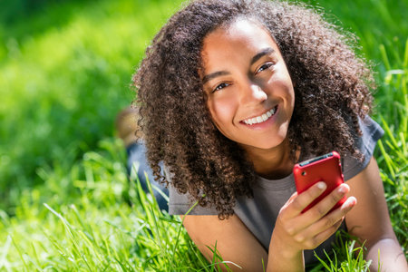 Outdoor portrait of beautiful happy mixed race African American girl teenager female young woman...