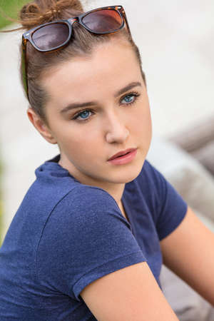 Pretty female teenager girl or young woman with blue eyes outside wearing sunglassesの写真素材