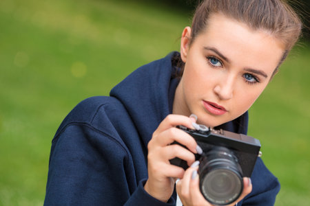 Beautiful happy girl teenager female young woman photographer outdoors in sunshine taking...