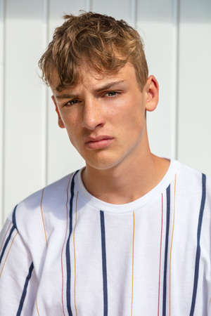 Young adult male boy teenager blond outside in summer sunshineの写真素材