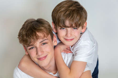 White background studio photograph of young happy boy children brothers smiling togetherの写真素材