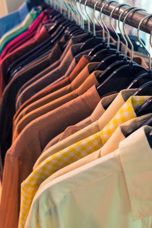 Vintage style image of male mens shirts on hangers in a shop display or wardrobe closet railの素材 [FY310124549323]