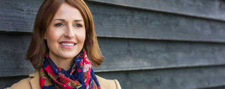 Panoramic portrait shot of an attractive, successful and happy middle aged woman female outside web banner panoramaの写真素材