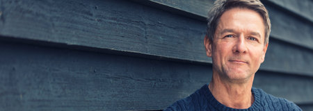 Panoramic web banner portrait shot of an attractive, successful and happy middle aged man male...