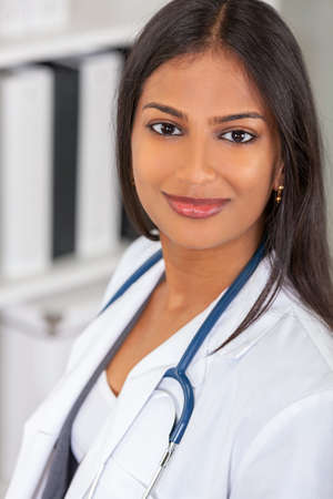 Portrait of Indian Asian female medical doctor in a hospital office happy and smiling with stethoscope
の写真素材