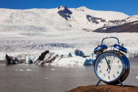 Alarm clock and melting glacier and icebergs climate change global warming concept Icelandの写真素材