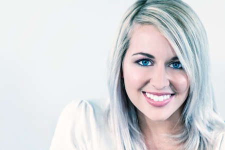 Portrait of beautiful girl or young woman smiling with perfect teeth and bright blue eyesの写真素材