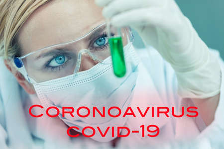 Female medical or research scientist or woman doctor looking at a test tube of in a Coronavirus COVID-19 vacine lab or laboratory with textの写真素材