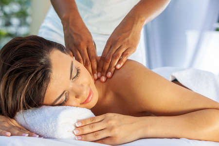 Young woman relaxing at a health spa while having a massageの写真素材
