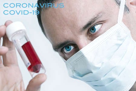 Male doctor wearing face mask with Coronavirus COVID-19 blood sample. Picture with text.の写真素材